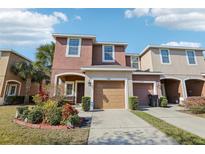 Two-story townhome with attached garage and landscaping at 7069 Towne Lake Rd, Riverview, FL 33578
