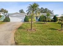 House exterior featuring a landscaped lawn, driveway, and attached garage at 7547 Barry Ct, Seminole, FL 33772