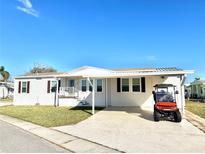 Charming single-story home with a well-manicured lawn and a convenient covered parking area at 145 Blue Marlin Dr, Oldsmar, FL 34677