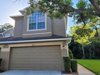 Tan two-story townhome with a two-car garage and landscaping at 18812 Duquesne Dr, Tampa, FL 33647