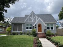 Charming craftsman home with gray siding, a wood door, and manicured lawn at 2327 Woodlawn E Cir, St Petersburg, FL 33704