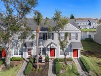 Two-story townhome with red door, landscaping, and a palm tree at 388 Countryside Key Blvd, Oldsmar, FL 34677