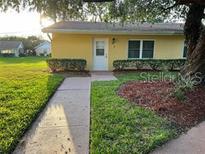 Exterior view of a yellow single-story home with well-maintained landscaping at 401 Dorchester Pl # 62, Sun City Center, FL 33573