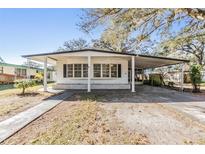 White single story home with carport and landscaped yard at 4711 Olive Dr, Zephyrhills, FL 33542