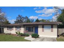 Charming single-story home features neutral siding, a blue front door, and well-maintained landscaping at 512 Greenbay Ave, Brandon, FL 33510