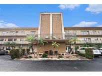 Two-story condo building with palm trees and ample parking at 5975 Terrace Park N Dr # 105, St Petersburg, FL 33709