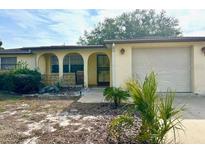 Ranch-style home with attached garage and mature landscaping at 7614 Karen Dr, Port Richey, FL 34668