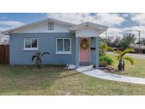 Cute bungalow with light blue exterior, pink door, and well-manicured lawn at 3046 35Th N Ave, St Petersburg, FL 33713