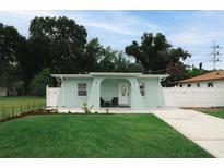 Charming light teal home with well-manicured lawn and a paved driveway at 3114 W Abdella St, Tampa, FL 33607