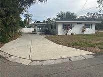 White single story home with a long driveway and mature landscaping at 3553 Center Cir, Largo, FL 33774