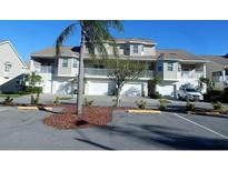 Three-story townhome with attached garage and landscaping at 8222 Brent St, Port Richey, FL 34668