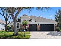 Charming single Gathering home featuring manicured landscaping, stone accents and a three-car garage at 15110 Shearcrest Dr, Lithia, FL 33547