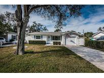 Charming single-story home with a well-manicured lawn, garage, and American flag displayed at 1570 S Michigan Ave, Clearwater, FL 33756