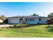 Single-story home with a gray exterior, attached garage, and well-maintained lawn at 18719 Van Nuys Cir, Port Charlotte, FL 33948