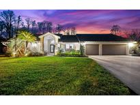 Attractive two-story house with a lush lawn and beautiful sunset at 3312 Cobbs Ct, Palm Harbor, FL 34684