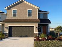 Two-story house with dark brown garage door and landscaping at 36111 Welsh Glade Rd, Dade City, FL 33525