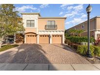 Tan three-unit building with three-car garage and paved driveway at 4079 Overture Cir # 346, Bradenton, FL 34209