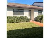 Exterior view of a single-story home with a well-maintained lawn at 7947 Radcliffe Cir, Port Richey, FL 34668