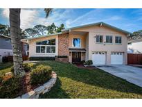 Two-story house with a brick facade, attached garage, and manicured lawn at 14311 83Rd Pl, Seminole, FL 33776