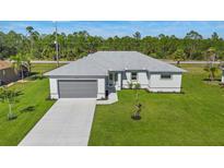 Aerial view of a single-story house with a gray roof and driveway at 25434 Alicante Dr, Punta Gorda, FL 33955