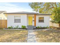 Charming bungalow with a yellow door, landscaping, and a walkway at 3034 Burlington N Ave, St Petersburg, FL 33713