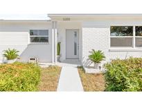 Charming home with a painted brick facade, well-kept landscaping, and a modern gray front door at 3499 43Rd N St, St Petersburg, FL 33713