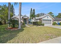 Charming home featuring beautiful landscaping, mature trees, and a well-maintained lawn at 4833 Yellowstone Dr, New Port Richey, FL 34655