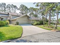 Tan two-story home with two car garage and lush landscaping at 5340 Cobblestone Ct, Wesley Chapel, FL 33543