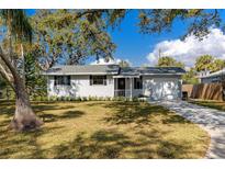 Updated bungalow with a landscaped yard, driveway, and a charming front porch at 6923 Dartmouth N Ave, St Petersburg, FL 33710