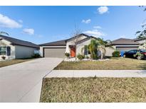 Charming single-Gathering home with well-maintained landscaping and a two-car garage at 11210 Kelly Green Ave, Wimauma, FL 33598