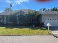 Single-story home with a large front yard, attached garage, and palm trees at 13184 73Rd Ave, Seminole, FL 33776