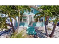 Charming light blue beach cottage with a front porch at 13405 Gulf Blvd, Madeira Beach, FL 33708