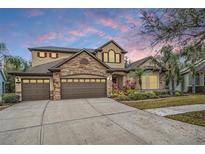 Two-story home with stone accents and a three-car garage at 19116 Sweet Clover Ln, Tampa, FL 33647