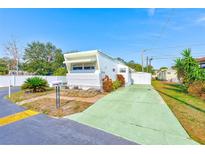 White mobile home with green driveway, landscaping, and a mailbox at 27466 Us Highway 19 N # 54, Clearwater, FL 33761