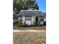 Quaint condo with gray roof, white exterior, and lush landscaping at 4221 Touchton Pl # A, New Port Richey, FL 34652