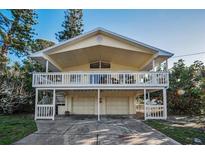 Charming two-story beach home with a large front porch and a two-car garage underneath at 523 Georgia Ave, Crystal Beach, FL 34681