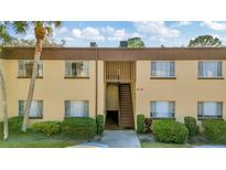 Exterior view of a two-story building with stairs and landscaping at 603 N Keene Rd # P12, Clearwater, FL 33755