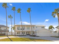 Two-story waterfront home with palm trees and a paved driveway at 7810 10Th S Ave, St Petersburg, FL 33707