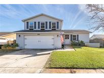 Two-story house with a white exterior, attached garage, and well-maintained lawn at 8416 121St Pl, Largo, FL 33773