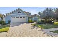 Charming light blue two-story home featuring a spacious driveway, a two car garage and lush landscaping at 952 Symphony Isles Blvd, Apollo Beach, FL 33572