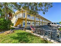 Bright yellow building with multiple units, parking, and bike racks at 9715 Harrell Ave # 25, Treasure Island, FL 33706