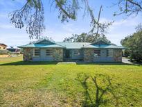 Charming single-story home features a stone facade and a large, well-manicured front lawn at 13050 110Th Ave, Largo, FL 33774