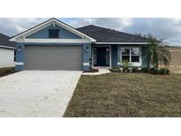 Newly constructed home with gray garage door and blue exterior at 13146 Kent Bradley St, Dade City, FL 33525