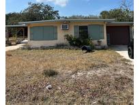 Ranch-style home with green shutters and a large yard at 1819 Grand Blvd, Holiday, FL 34690