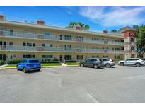 Two-story condo building with parking and lush landscaping at 2263 Americus E Blvd # 59, Clearwater, FL 33763