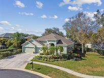 Single-story house with a two-car garage, lush landscaping, and a large backyard at 3710 Rain Tree Ct, Palm Harbor, FL 34685