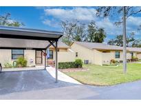 Exterior of charming villa with carport, well-manicured lawn, and inviting entryway at 38351 Ironwood Pl, Zephyrhills, FL 33542