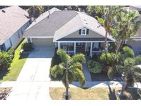 Single-story house with a landscaped yard and driveway, perfect for a Gathering at 404 Manns Harbor Dr, Apollo Beach, FL 33572