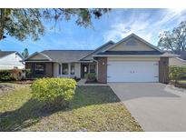 Brick ranch home with attached garage and manicured lawn at 4804 Foxshire Cir, Tampa, FL 33624