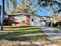 Brick ranch house with a driveway and a yard at 4865 163Rd N Ave, Clearwater, FL 33762